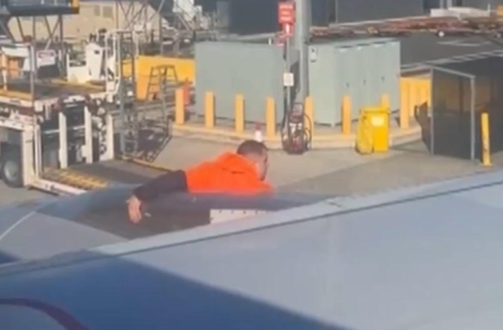 一名男子在機翼上行走,並走到停機坪。(X)