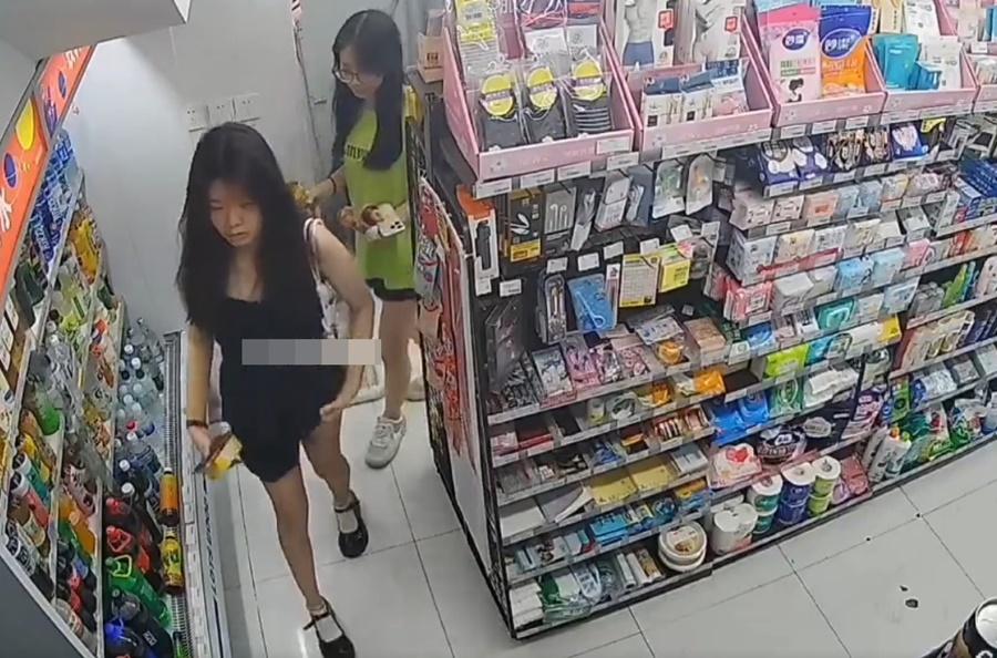 女子趁著店員服務顧客時,快速拉起短裙,將香煙收藏到內褲裡,之後整理短裙。(微博)