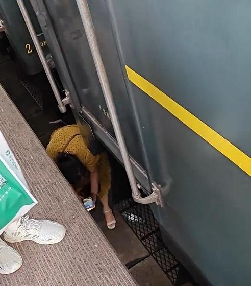 女子逕自打開手機照明燈,再於車底下搜尋眼鏡。(微博)