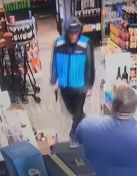 男子從口袋掏出一把槍狀物,走到櫃台前聲稱要「打劫」。(YouTube)