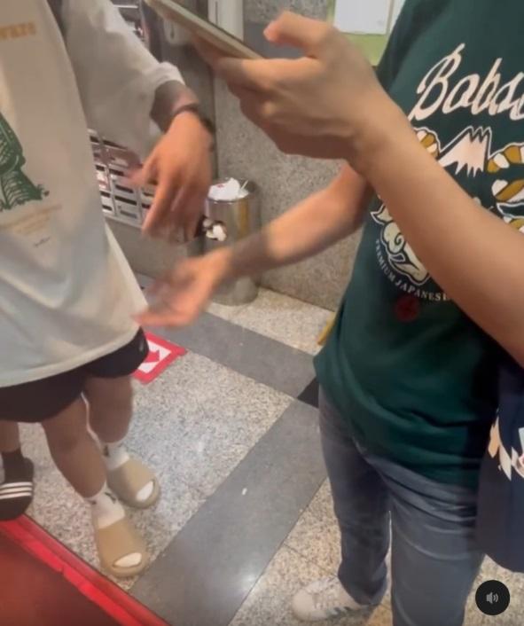 白衣男子用手撥開拍偷男子的手,警告他切勿刪去手機中的照片。(網片截圖)