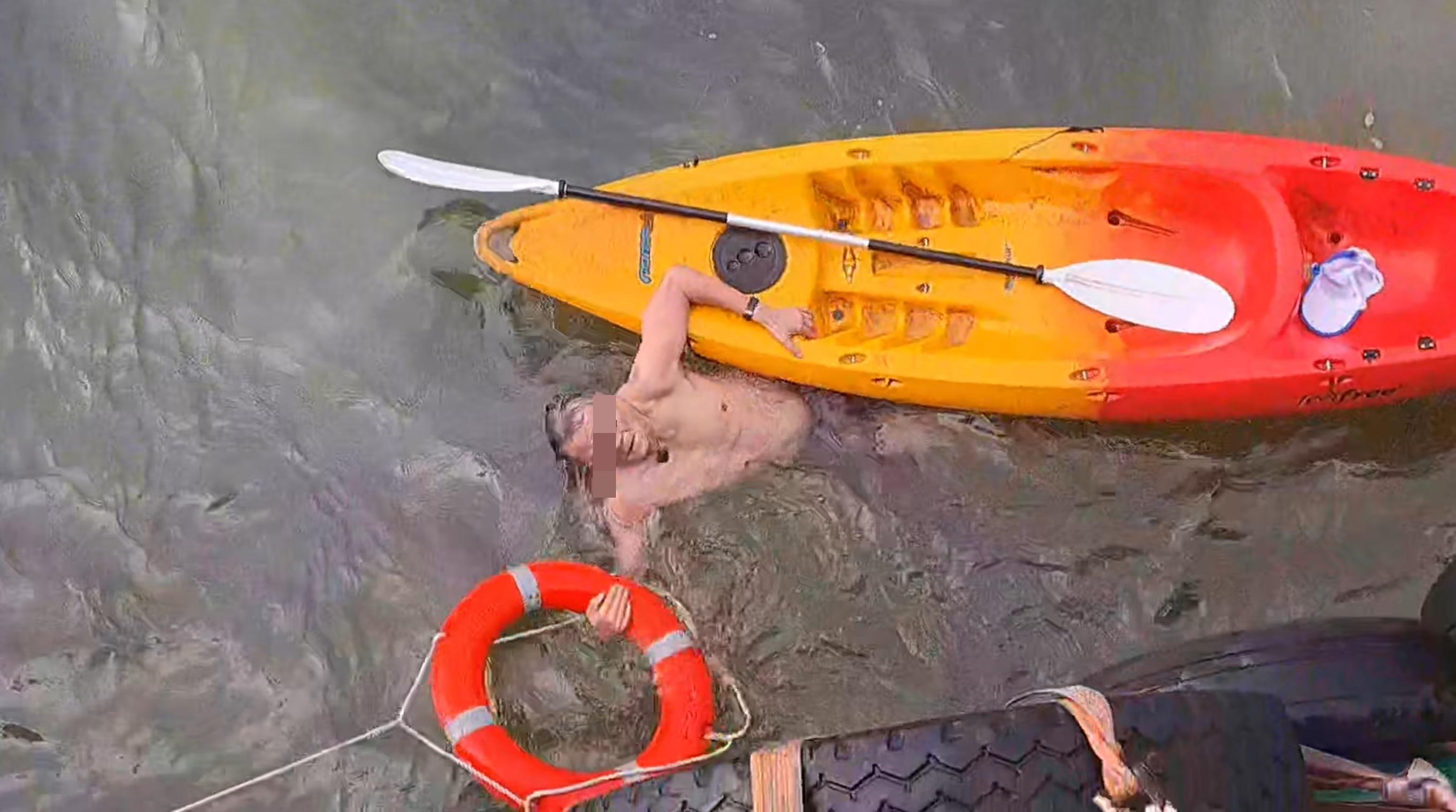 男子用手抱著救生圈,以免被海水漂走。(網片截圖)