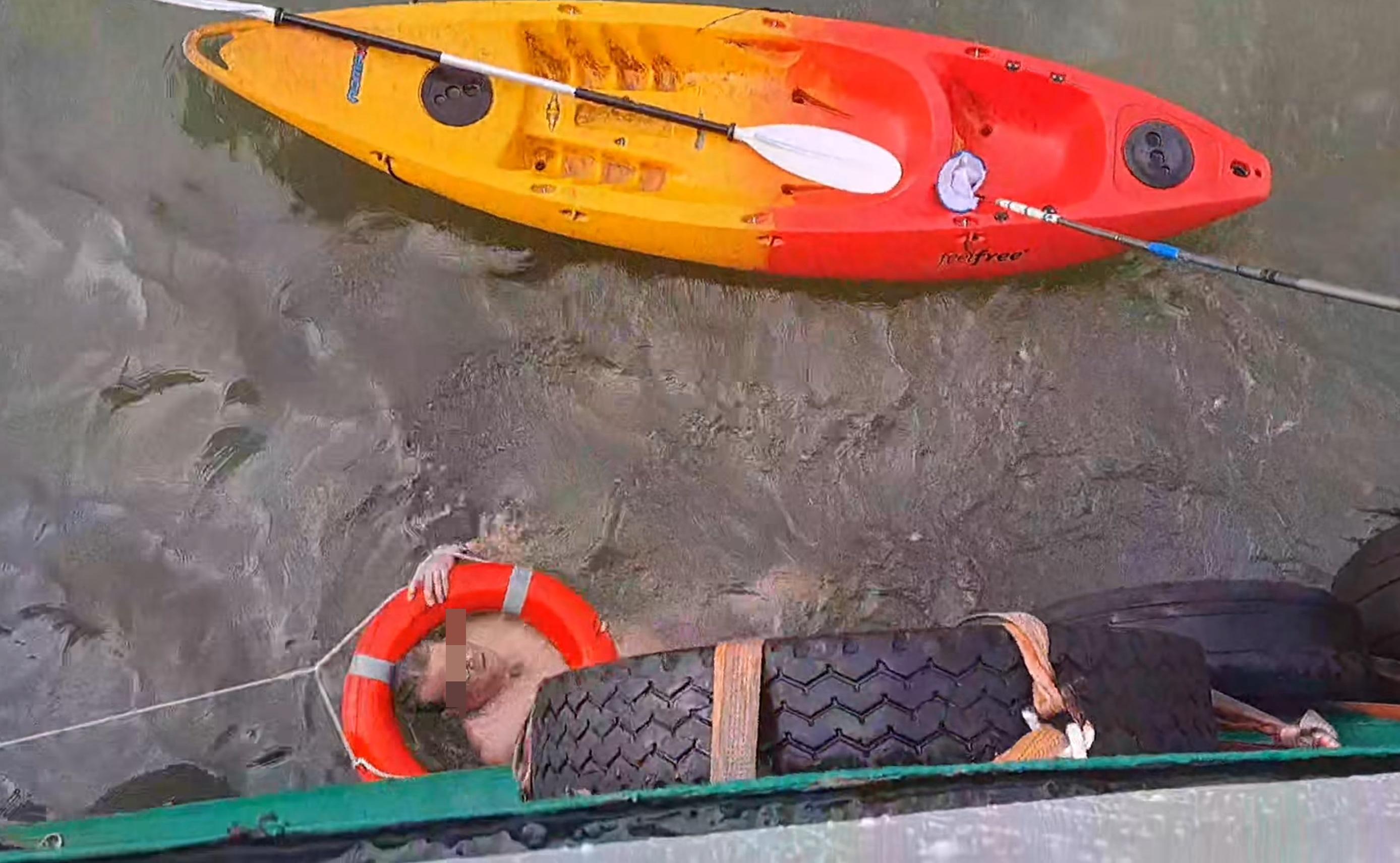男子用手抱著救生圈,以免被海水漂走。(網片截圖)