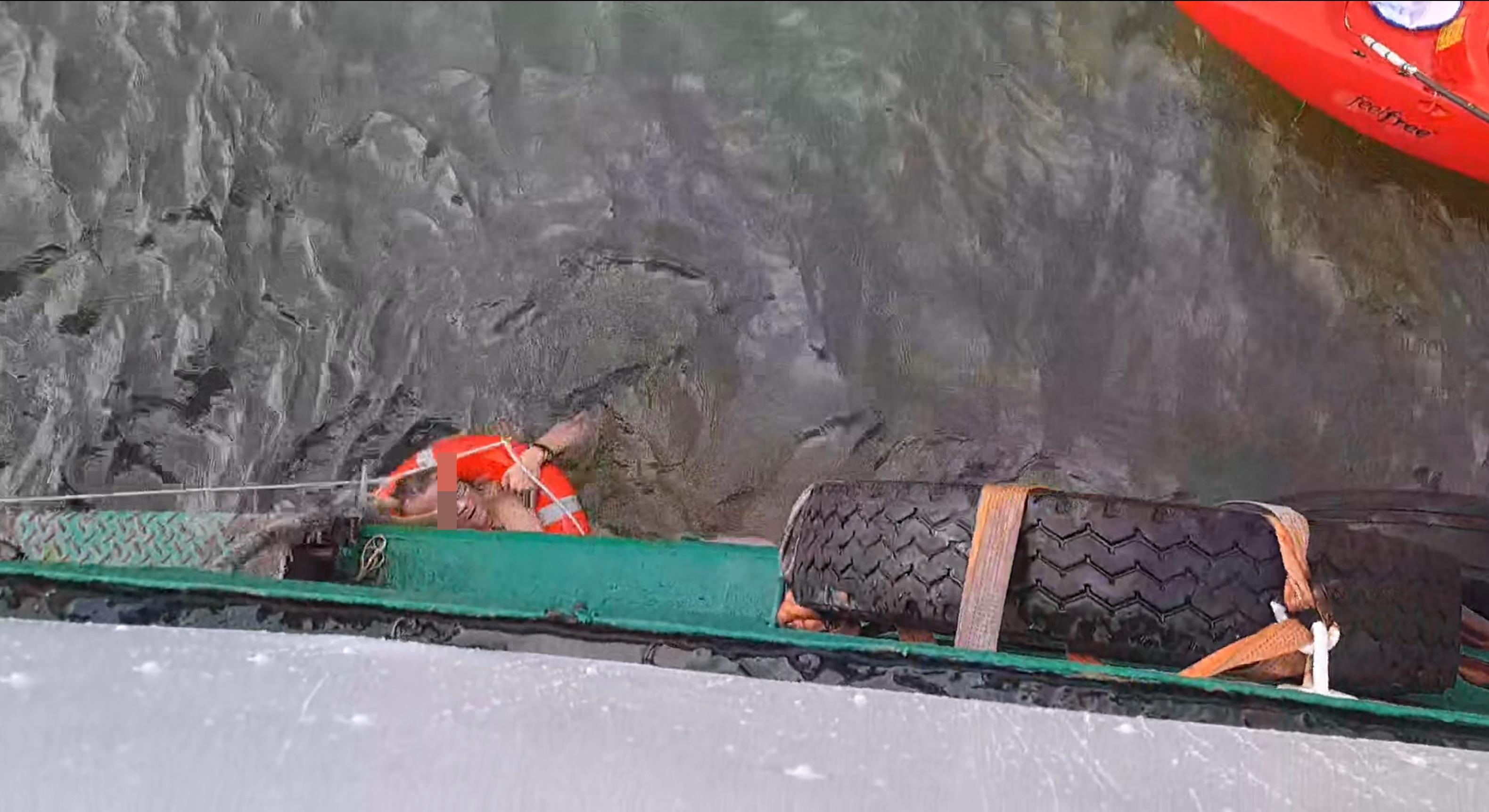 男子用手抱著救生圈,以免被海水漂走。(網片截圖)