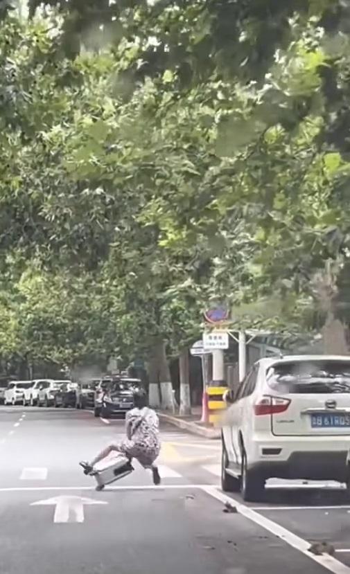 車Cam直擊|內地大媽疑坐喼當交通工具,失控自炒跌倒。(網片截圖)