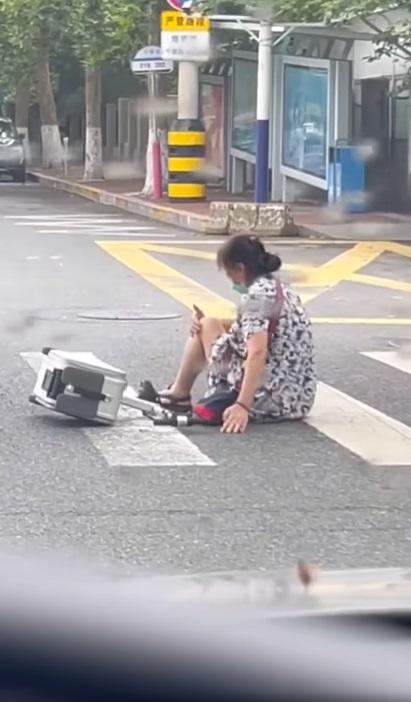 車Cam直擊|內地大媽疑坐喼當交通工具,失控自炒跌倒。(網片截圖)