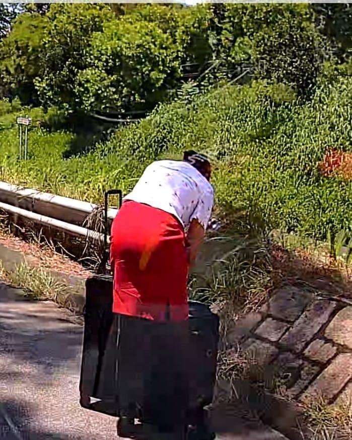 一輛綠色的士於屯門青雲路行駛期間,前方突出現一名帶行李喼的國泰女空姐。(影片截圖)