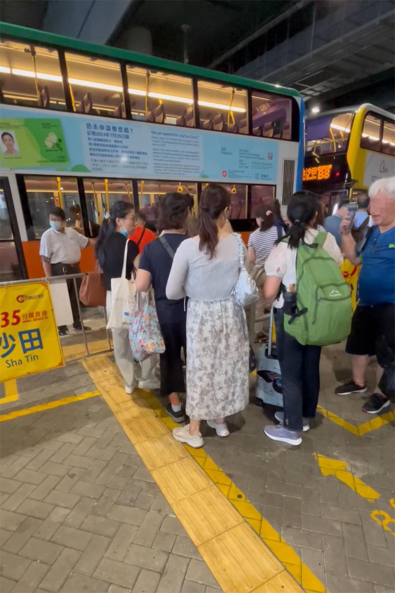 婦人到達隊伍排隊後,仍然不甘示弱批評巴士公司「大把位都唔畀人上」。(網民UE Wong影片截圖)