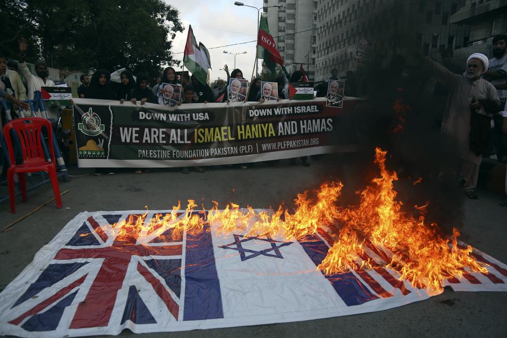 哈尼亞在伊朗被空襲暗殺身亡,令中東局勢升級,多地觸發示威。巴基斯坦有示威者焚燒美國、以色列、英國國旗 (美聯社)