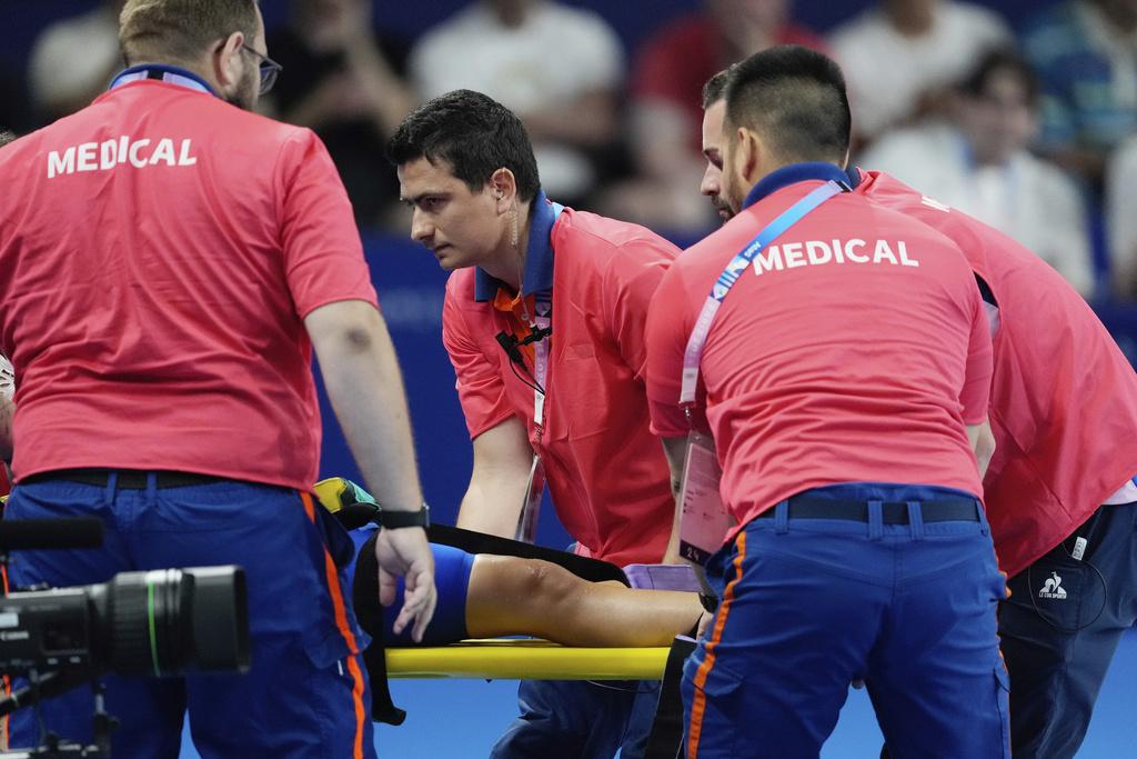 斯洛伐克泳手在池邊暈倒要被擔架抬走。(美聯社)