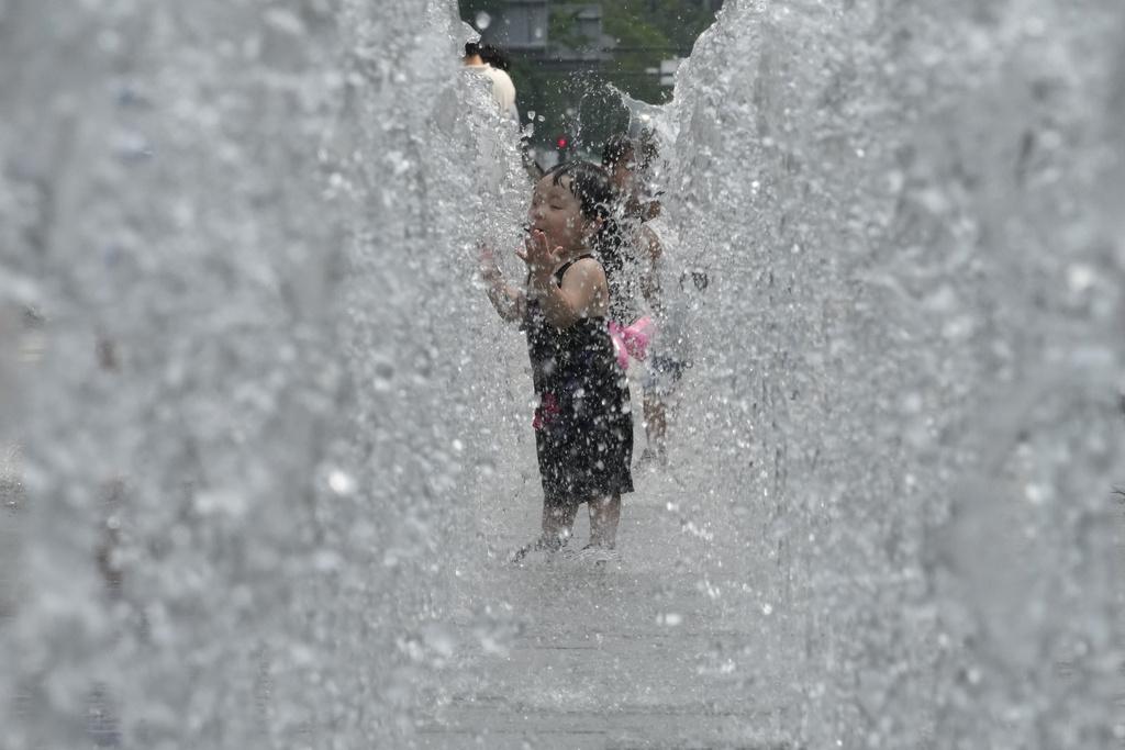 南韓首爾民眾在噴泉降溫。(美聯社)