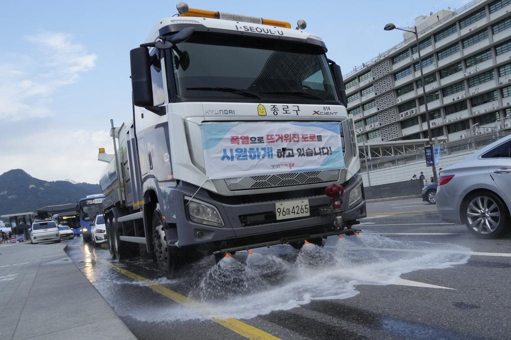 南韓首爾民眾在噴泉降溫。(美聯社)