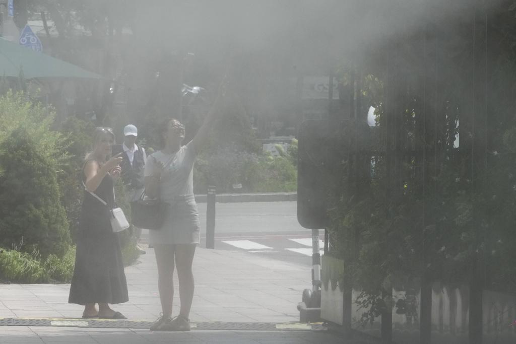 南韓首爾民眾在噴泉降溫。(美聯社)