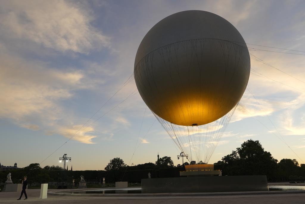 在今屆奧運為法國贏得四金一銅游泳獎牌的泳手馬桑,身穿黑西裝手持聖火揭開閉幕禮的序幕。(美聯社)