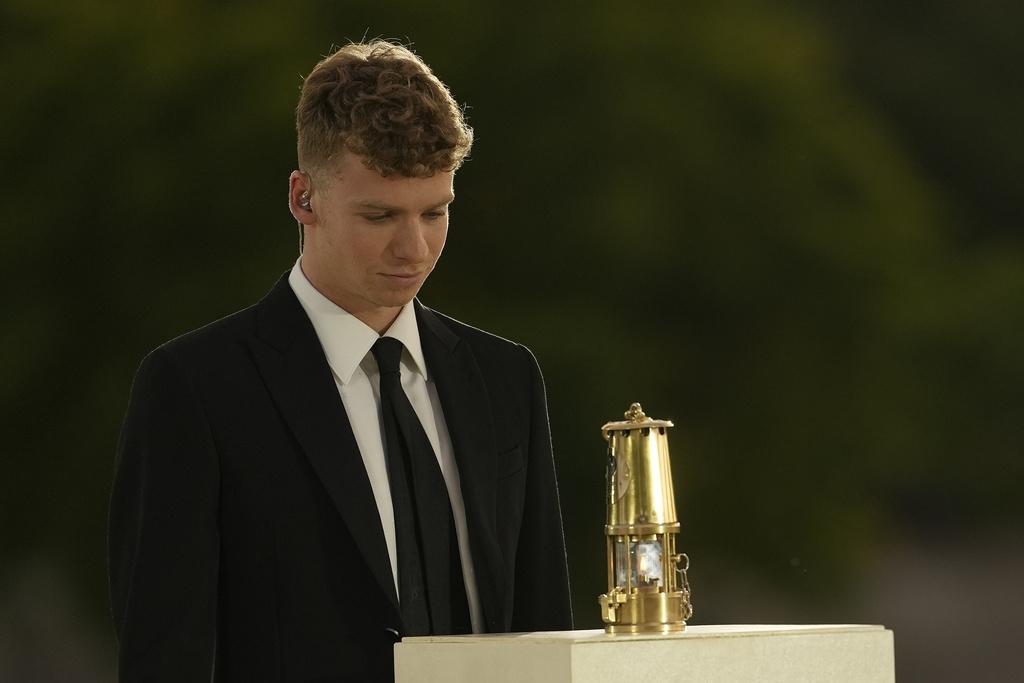 在今屆奧運為法國贏得四金一銅游泳獎牌的泳手馬桑,身穿黑西裝手持聖火揭開閉幕禮的序幕。(美聯社)