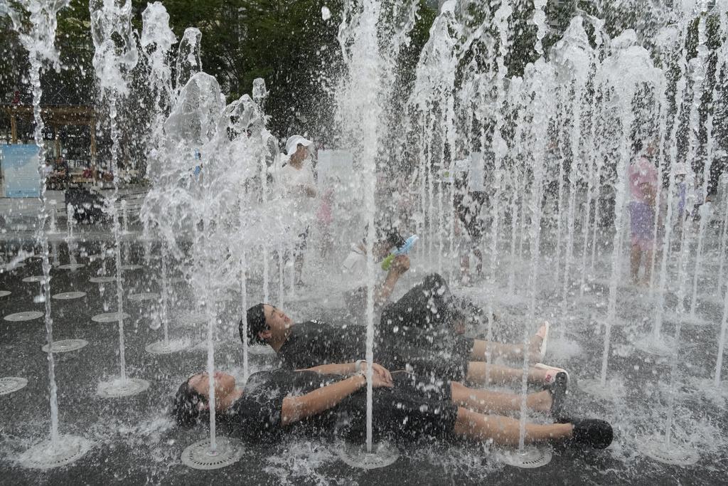 南韓首爾民眾在噴泉降溫。(美聯社)