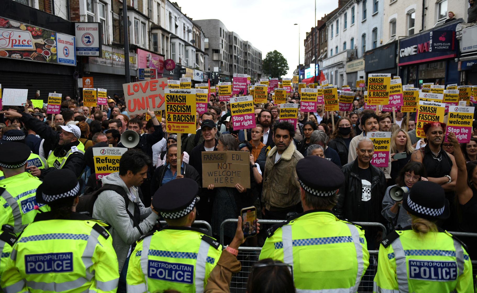 在倫敦,有民眾舉行反種族主義、反暴力遊行,大批警員維持秩序,分隔不同意見人士,過程大致和平。(路透社)