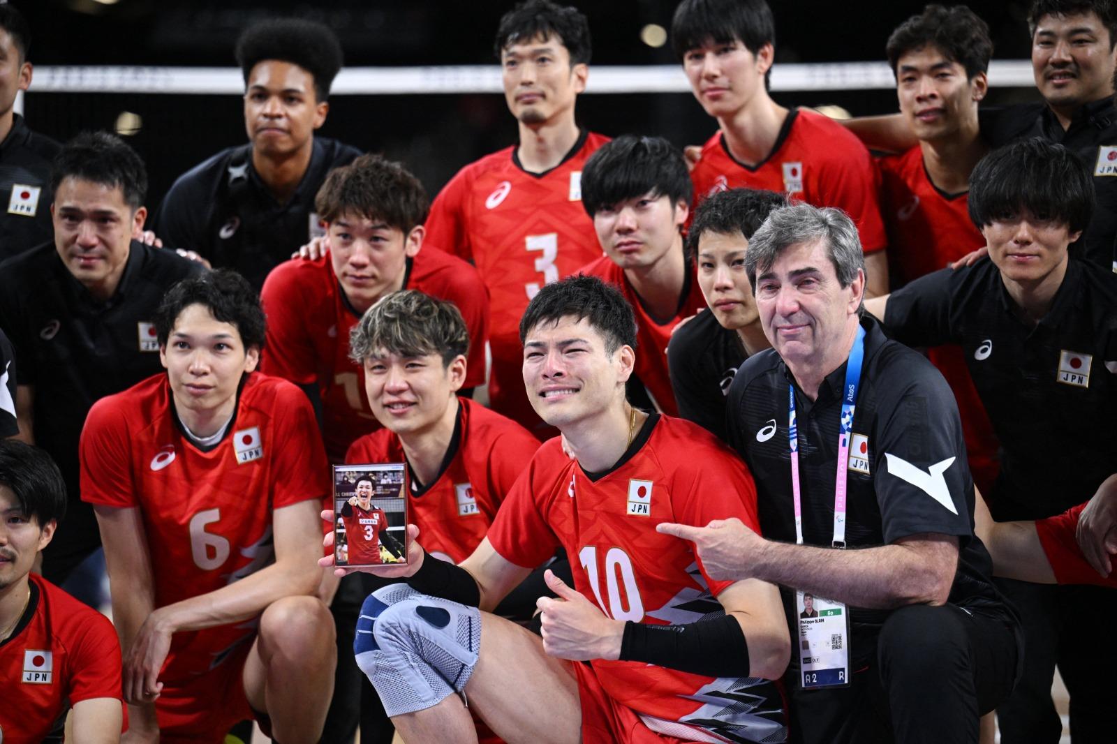 日本男子排球隊在巴黎奧運不敵意大利出局,高橋健太郎手持已故前日本二傳手藤井直伸照片。(路透社)