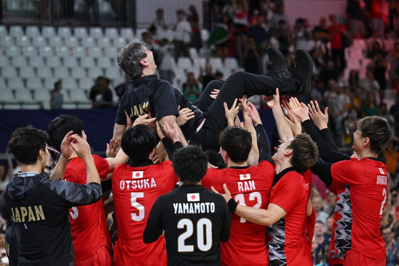 日本男子排球隊在巴黎奧運不敵意大利出局,仍捧起法國籍教練Philippe Blain。(路透社)
