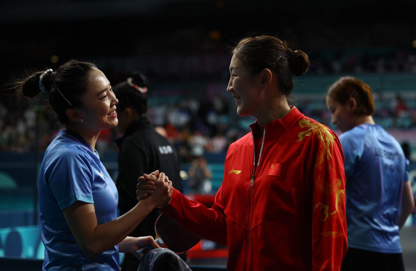巴黎奧運|南韓乒乓女將田志希與中國的陳夢握手。(路透社)