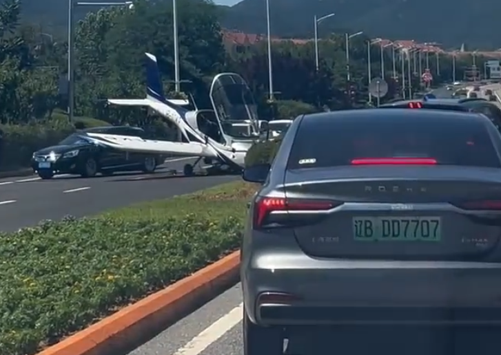 遼寧大連一架小型飛機疑失控迫降公路上,差一點就砸到路過車輛,驚險畫面在社交平台瘋傳。(網上圖片/影片截圖)