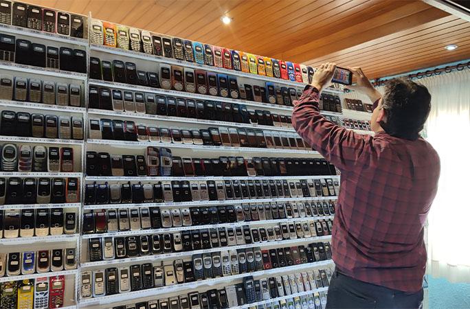 於巴塞隆拿居住的費爾南德斯(Wences Palau Fernandez) 收藏擁有3,615款不同的手機,成為全球手機收藏量最多的人。(健力士影片截圖)