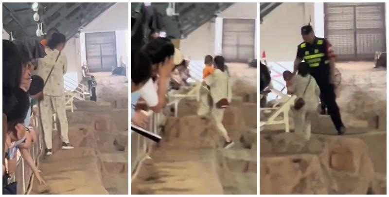 一名母親抱孩子參觀時,突直接跨過護欄走在兵馬俑坑坑道上,最終被保安帶走。(影片截圖)
