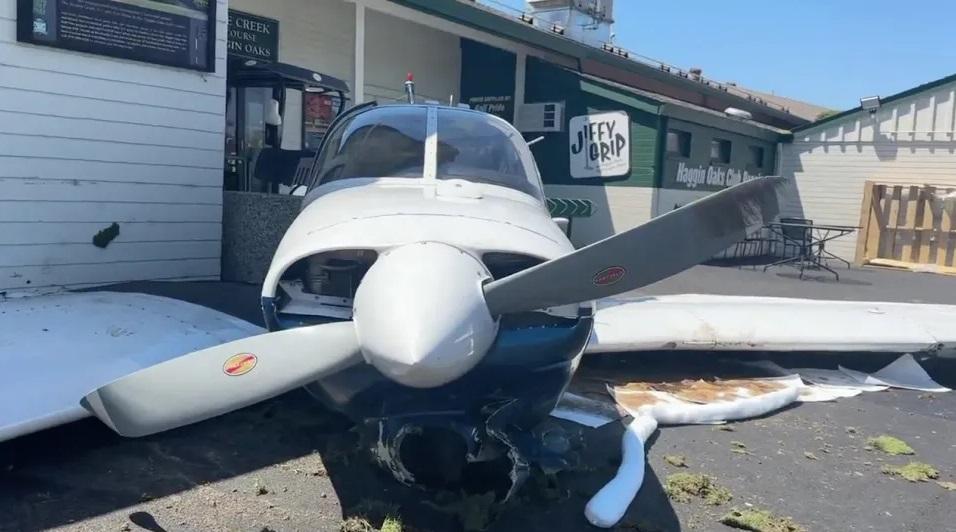 小型飛機撞到球場專賣店後停下。(互聯網)