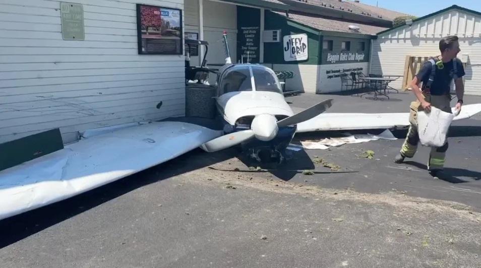 小型飛機撞到球場專賣店後停下。(互聯網)