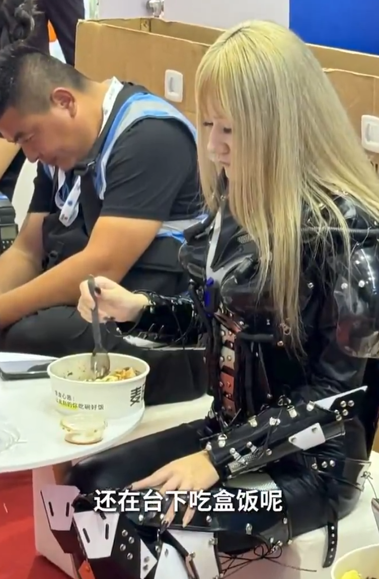 有由真人經特技化妝扮成的機器人中午休息時在午餐。(影片截圖)