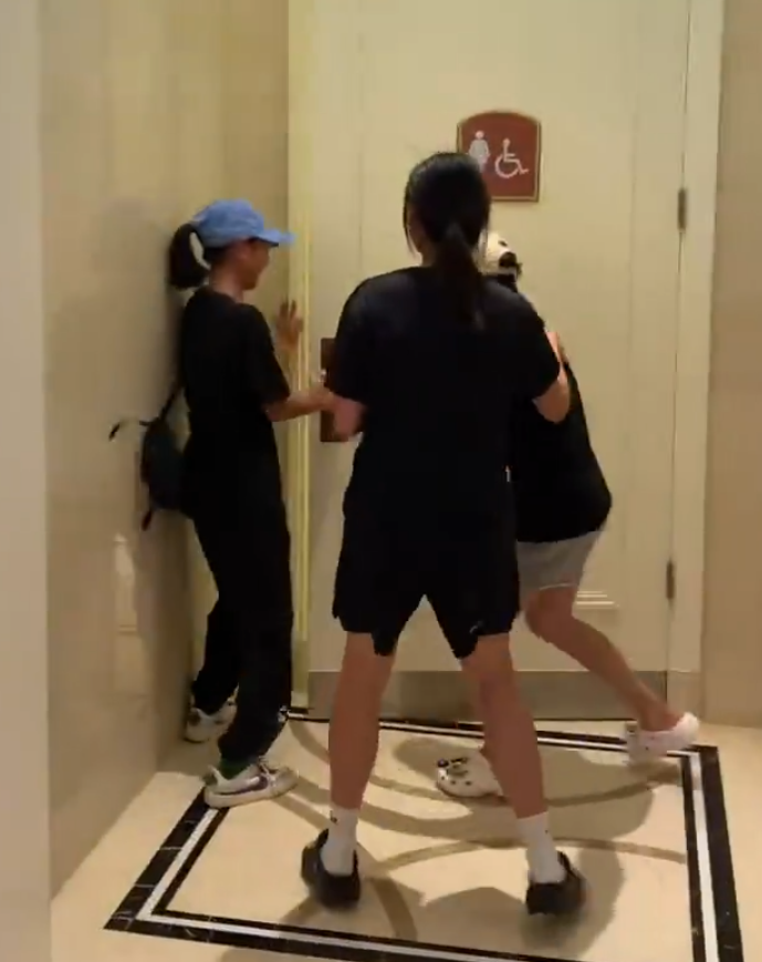 全紅嬋(右)穿上便服、戴了帽子及口罩,返回酒店時被在現場等候的粉絲發現,全紅嬋即與兩名女子跑入酒店的女廁(影片截圖)