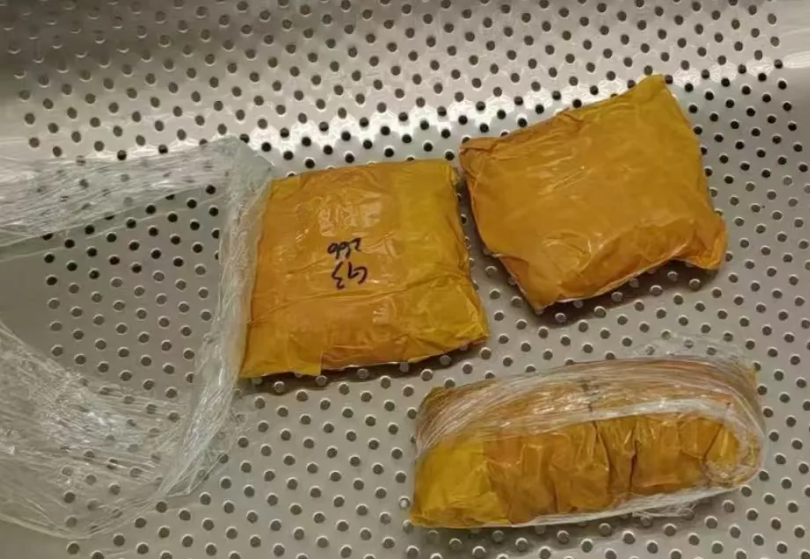 內地海關在皇崗口岸發現一名女旅客舉止異常,在其胸部發現兩袋用保鮮紙纏繞固定的黃色膠紙包裝物,另在其裙下打底褲襠部發現一袋同樣的黃色膠紙包裝物,查獲黑珍珠626粒。(內地海關總署)