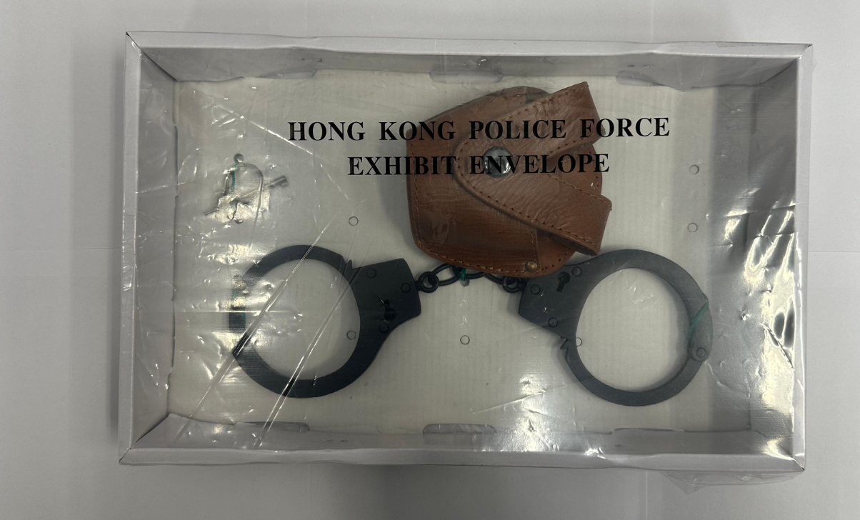 警方突擊搜查紅磡一住宅單位,檢獲8枚煙霧彈、14枝仿製槍械、1枝伸縮棍、1副手鐐、1把長刀以及1張偽造的警察委任證,一名39歲男子及一名47歲女子被捕。(警方提供)