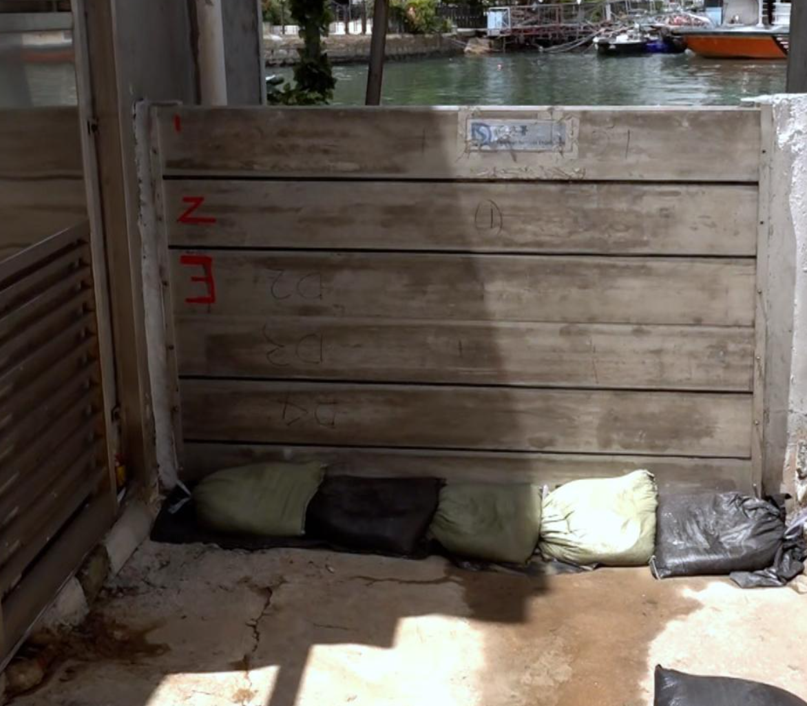 在鯉魚門三家村,有商戶加裝水閘及放置沙包。(港台圖片)