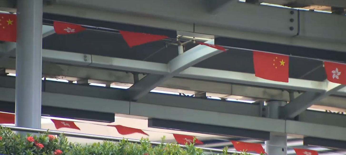 市民發現在新蒲崗橫跨太子道東、連接Mikiki商場的行人天橋上,所掛國旗和區旗在上周颱風摩羯吹襲後不少出現破損,路政署回覆傳媒稱已經完成更換。(有線新聞畫面)