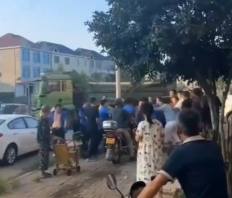 江西省撫州市東鄉區一間特色粉店門前,多名身穿城管制服的人員,圍毆倒地的兩名店主。(影片截圖)