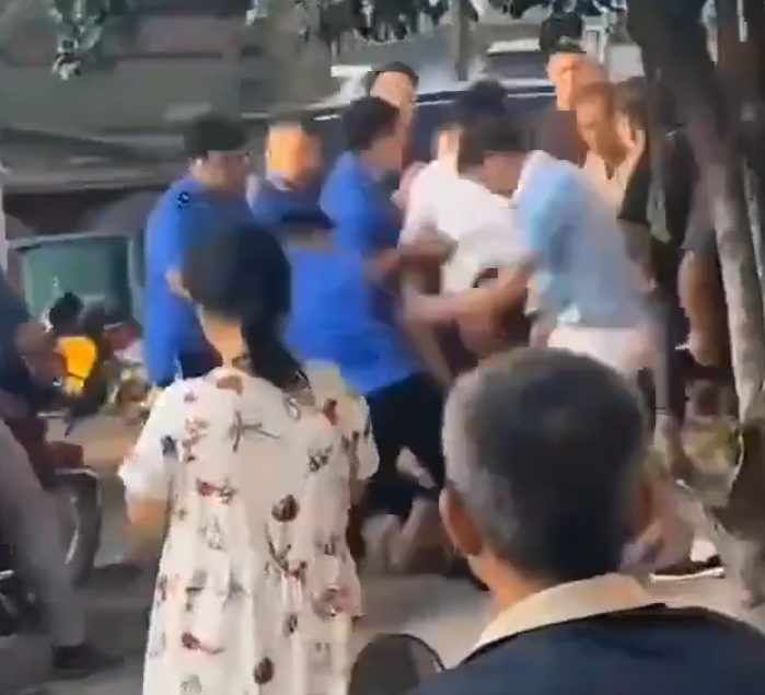 江西省撫州市東鄉區一間特色粉店門前,多名身穿城管制服的人員,圍毆倒地的兩名店主。(影片截圖)