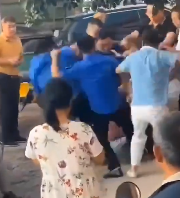 江西省撫州市東鄉區一間特色粉店門前,多名身穿城管制服的人員,圍毆倒地的兩名店主。(影片截圖)