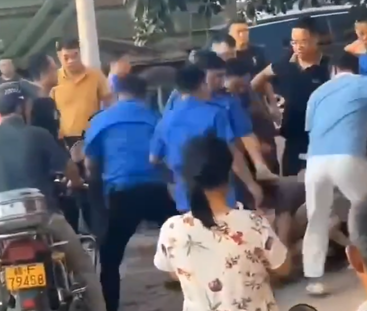 江西省撫州市東鄉區一間特色粉店門前,多名身穿城管制服的人員,圍毆倒地的兩名店主。(影片截圖)
