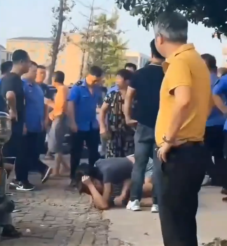 江西省撫州市東鄉區一間特色粉店門前,多名身穿城管制服的人員,圍毆倒地的兩名店主。(影片截圖)