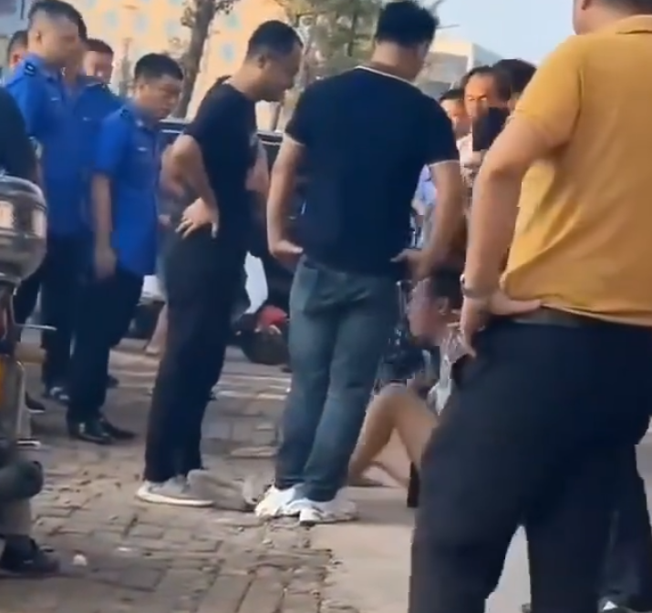 江西省撫州市東鄉區一間特色粉店門前,多名身穿城管制服的人員,圍毆倒地的兩名店主。(影片截圖)