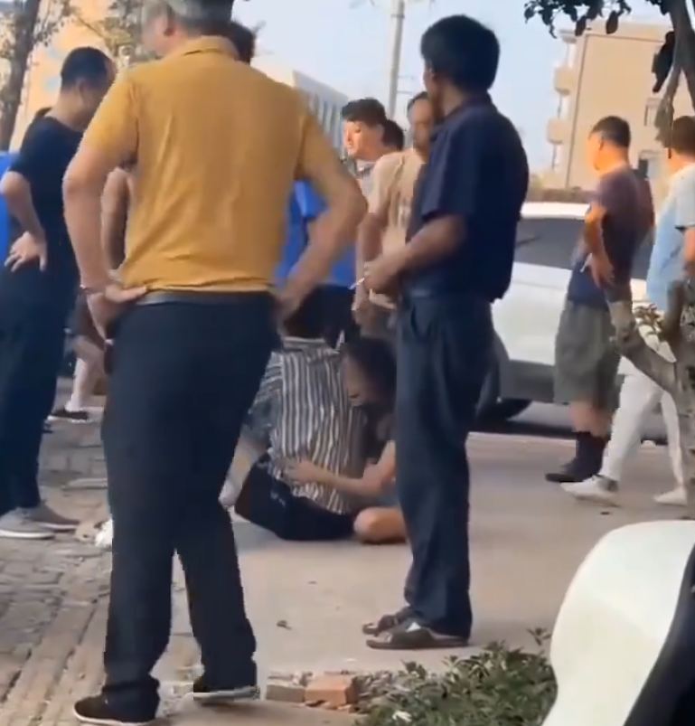 江西省撫州市東鄉區一間特色粉店門前,多名身穿城管制服的人員,圍毆倒地的兩名店主。(影片截圖)