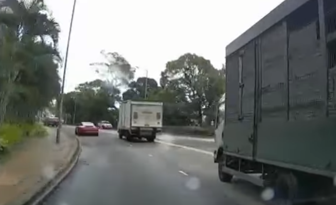 港島薄扶林道近瑪麗醫院路段一名男子推着需坐輪椅的長者於路邊「慢步」,與車輛驚險擦身而過,Cam主發現後即時響咹煞車爆粗,大罵男子行為危險。(影片截圖)