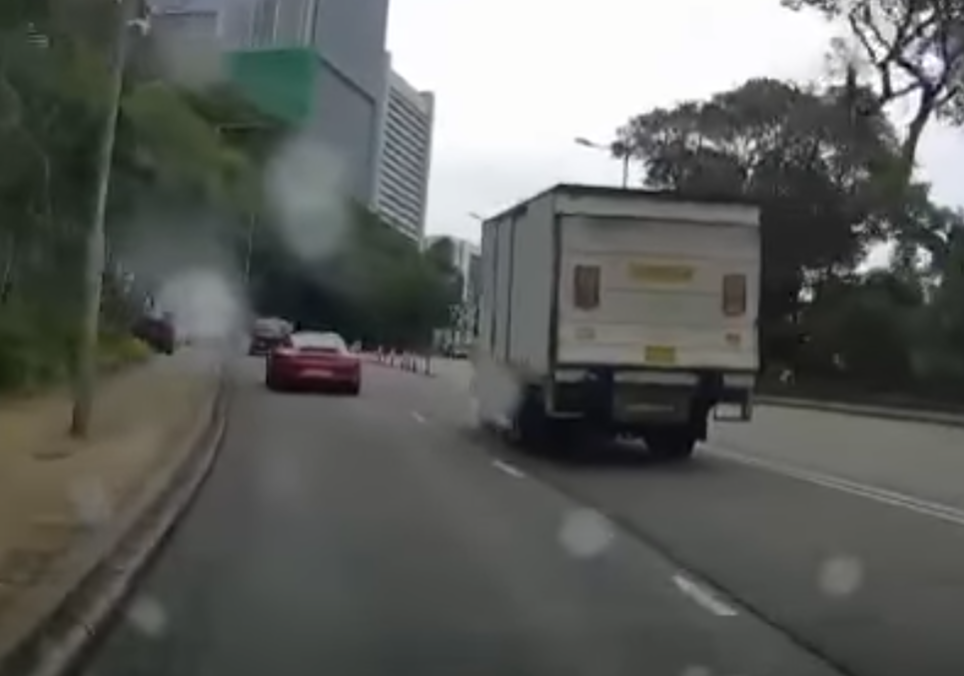 港島薄扶林道近瑪麗醫院路段一名男子推着需坐輪椅的長者於路邊「慢步」,與車輛驚險擦身而過,Cam主發現後即時響咹煞車爆粗,大罵男子行為危險。(影片截圖)