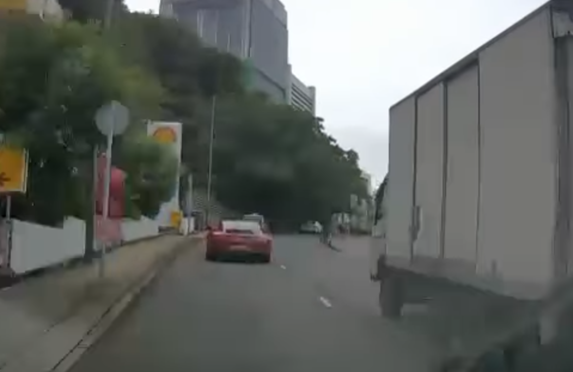 港島薄扶林道近瑪麗醫院路段一名男子推着需坐輪椅的長者於路邊「慢步」,與車輛驚險擦身而過,Cam主發現後即時響咹煞車爆粗,大罵男子行為危險。(影片截圖)
