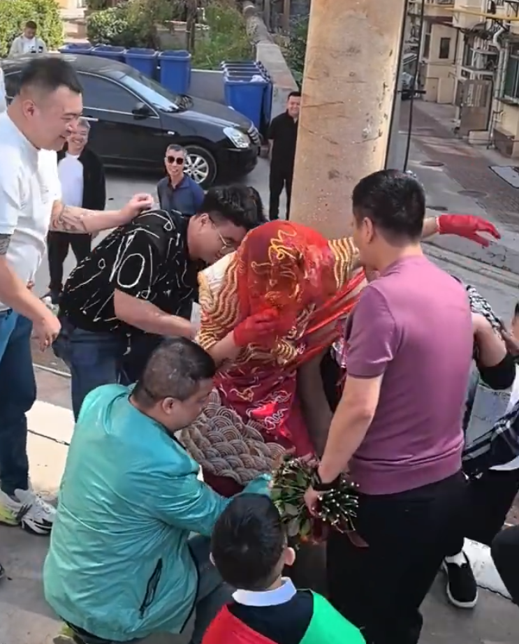 其間新娘喊叫掙扎但無人理會,疑似新郎手持鮮花用手攙扶著新娘,未有阻止眾人行為。(影片截圖)