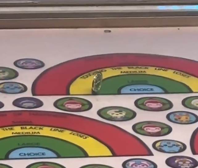 一名女網民於冒險樂園玩擲彩虹,擲出「屹立不倒」的90度角垂直代幣,置於綠色第二大獎範圍,惟卻明顯「擲界」,但店員仍計她中獎,又指對方「笑到傻直接話我中」。 社交平台Threads