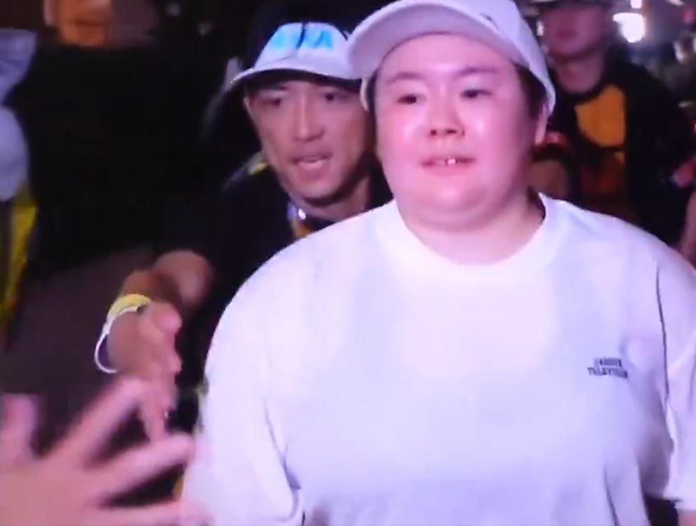 一名站在路旁的中年男子面露笑容突然伸出手迎向安子身體。(X)