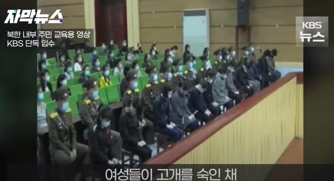 多名女子低著頭坐在第一排,她們因觀看韓劇而被戴上手銬公開受審。(YouTube)