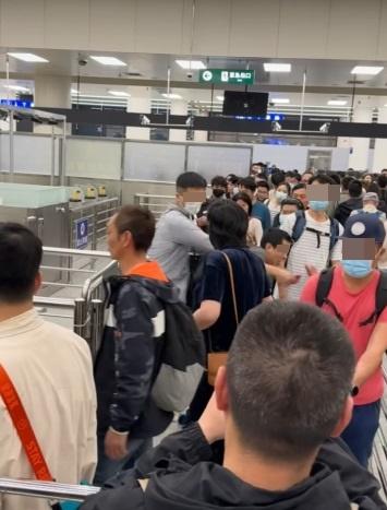 一名身形較矮的灰衣男子擋住另一名高大的戴眼鏡男子的去路,但隨即被對方一手推開,撞向欄杆。(網片截圖)